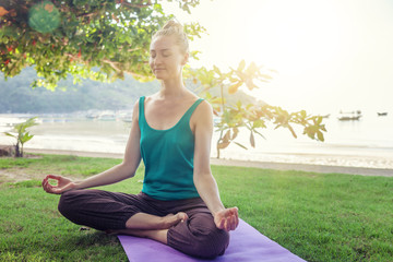 Young woman doing yoga outdoors. Healthy lifestyle, meditation, lifestyle concept