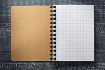 checked notebook at wooden  background