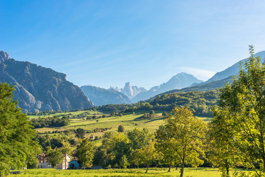The foothills of the National Park Los Picos de Europa in the north of Spain. In the background, peaks of the famous limestone mountain range and the Naranjo de Bulnes