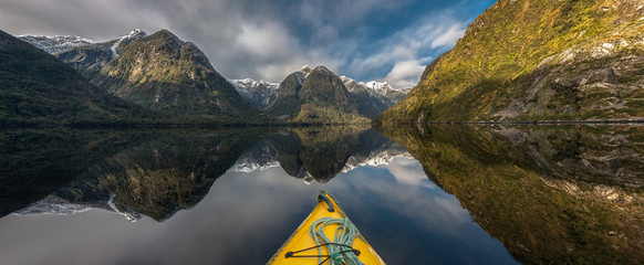 Panoramic view of Doubtful Sound, New Zealand, seen over the tip of a canoe in the foreground