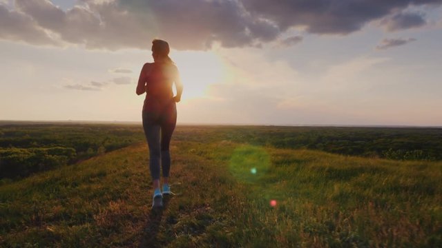 A close target - a woman runs down the hill in a picturesque place. She was tired, her lace on the sneaker untied. Concept - forward movement, purposefulness, victory