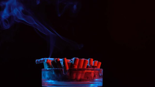 Smoldering cigarette in an ashtray rotate on a table