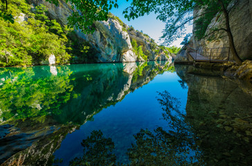 Fototapeta na wymiar Basses Gorges du Verdon prés de Quinson au printemps. Provence. France. Un beau reflet sur l'eau calme.