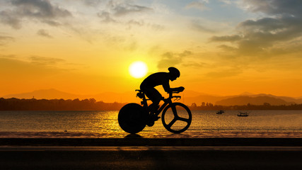 Fototapeta premium Man cycling at beach evening time