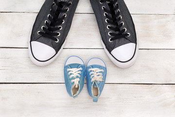 Daddy's boots and baby's shoes, fathers day concept. flat lay