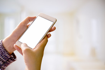 Woman holding smart phone with blurred backgroung.