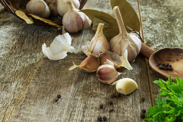 Heads and cloves of garlic on a blurred wooden background