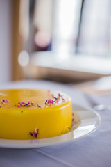 Culinary blog background. Delicious low sugar lemon cheesecake decorated with flowers served on a white table. Instagram style.