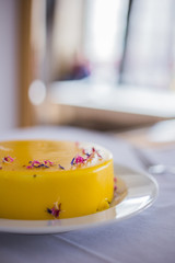 Culinary blog background. Delicious low sugar lemon cheesecake decorated with flowers served on a white table. Instagram style.