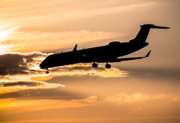 Airplane landing at sunset