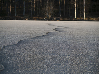 Riss im Eis eines zugefrorenen Sees
