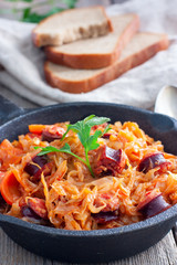 Cabbage stew with grilled sausage - traditional dish of german cuisine, Selective focus