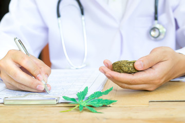 Female medicine doctor hand hold and offer to patient medical marijuana in jar. Cannabis recipe for...