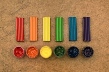 Gouache and plasticine set on top of a wooden background