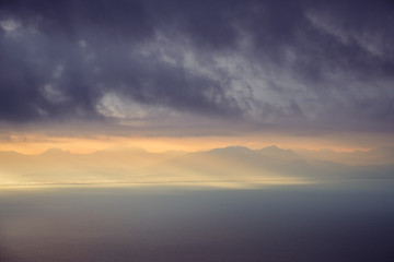 Dramatic landscape view of sunrise over mountains and the ocean
