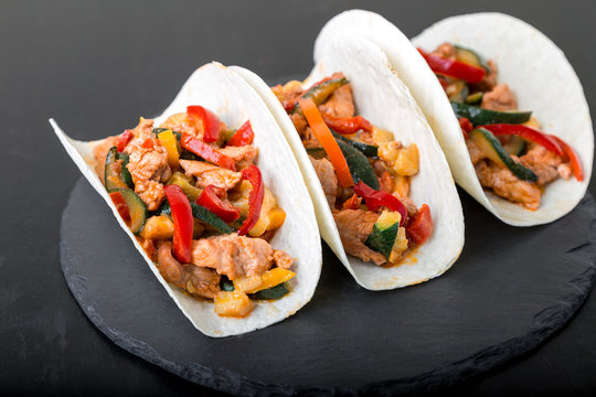 Mexican tacos with pork and vegetables. Al pastor taco on slate tableware...