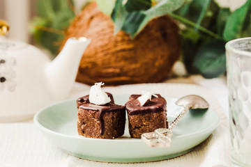 Fototapeta na wymiar Raw chocolate candy with nuts and coconut, healthy vegan dessert