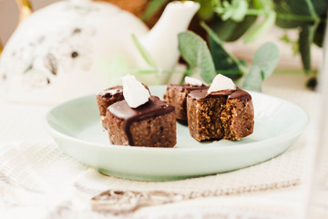 Raw chocolate candy with nuts and coconut, healthy vegan dessert