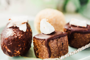 Raw chocolate candy with nuts and coconut, healthy vegan dessert