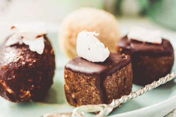 Raw chocolate candy with nuts and coconut, healthy vegan dessert