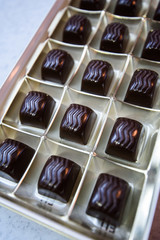 Chocolate appetizing candies with a various stuffing in the golden box. Mass production.