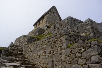 Guardhouse atop the intricate stone work and terracing of Incan ruins.  