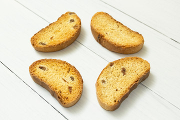 Fragrant crackers with raisins on a white wooden table, snack.