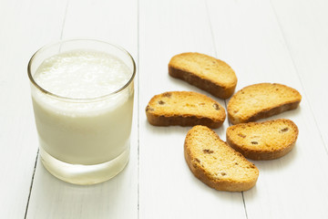 Dietary breakfast, sour yogurt in a glass cup and croutons with raisins on a white table, slimming.