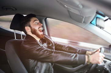 A young man scared screaming at the wheel of the car before the accident. Road traffic accident,...