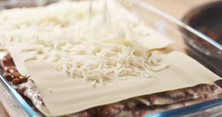 preparing traditional italian lasagna adding cheese, 4k photo