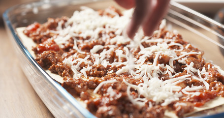 preparing traditional italian lasagna adding cheese, 4k photo