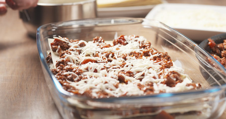 preparing traditional italian lasagna adding cheese, 4k photo
