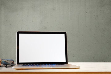 Laptop showing blank screen computer, antique toy on wood table. Copy space for product or graphic montage.