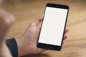 closeup shot of female teen hands with smartphone at the table, shallow focus