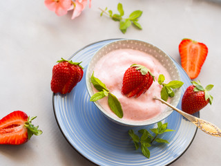 Home made strawberry ice cream in bowl with min leaves