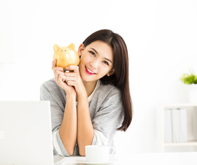 smiling young woman holding  piggy bank .