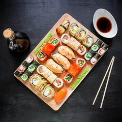 Fototapeta na wymiar Restaurant food. Sushi rolls, soy sauce and traditional chopsticks on a black background. Top view. Flat lay.
