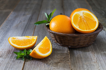 Whole and cut oranges with mint leaves