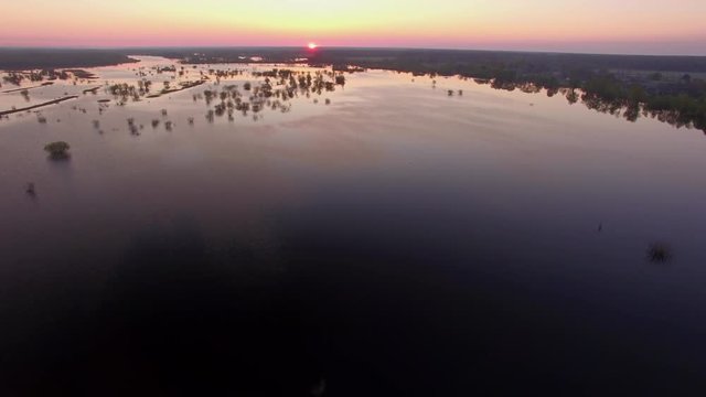 Sunrise at flooded land 4k. Fly over river floodplain in spring high water season in spring in East Europe discovery style copter shot. Pripiat river national park in Belarus