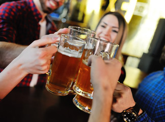 Company friends drink beer and smile