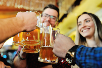 Company friends drink beer and smile