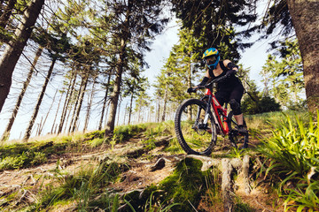Woman riding on hard track MTB bike in woods