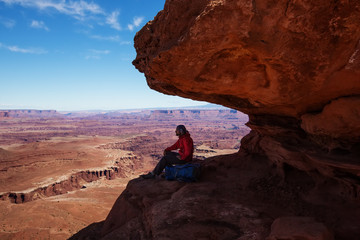 Hiker rests in Canyonlands National park in Utah, USA