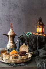 Ramadan kareem with premium dates,nuts and arabic tea. Festive still life with oriental ramadan lantern and iftar food concept.