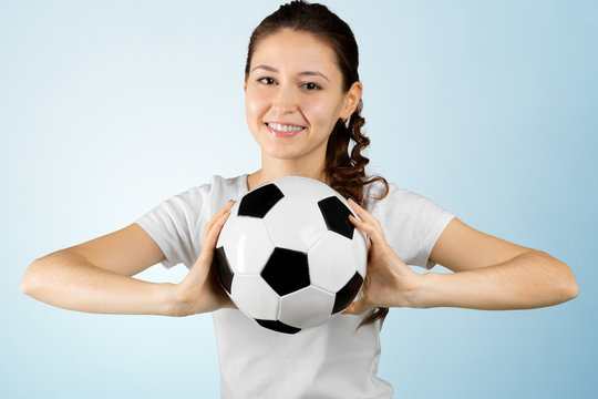 young woman holding soccer ball on her hand