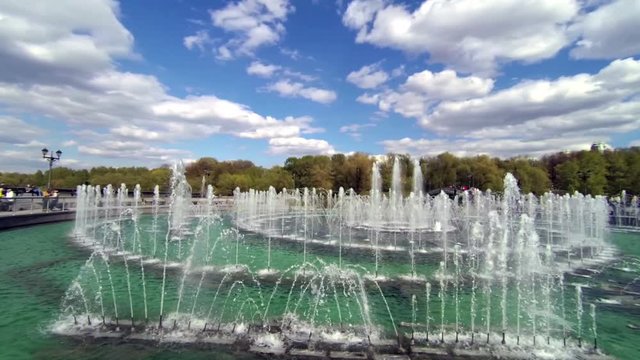 Panorama of a large fountain in the park on a summer day. slow motion