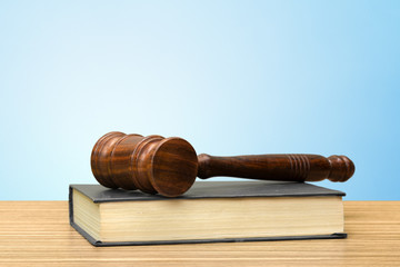 Wooden gavel and books on wooden table