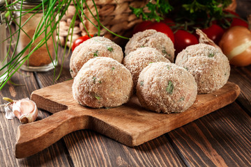 Raw meatballs rolled in a crispy bun prepared for baking