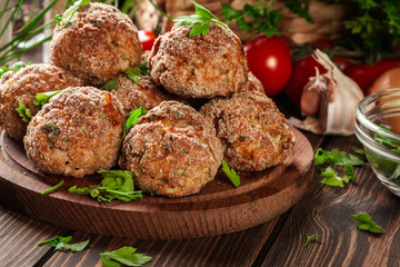 Stack of baked meatballs on a chopping board