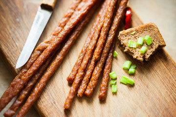 Fresh kabanos sausages, bread, knife and onion 